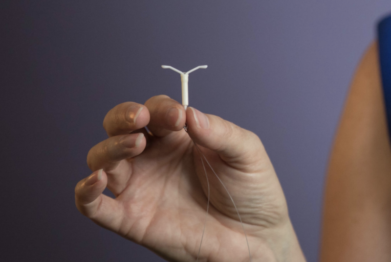 a hand holding the Mirena IUD