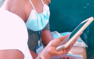 Web chatbot – Population Council a woman wearing a surgical mask looking at a mobile phone