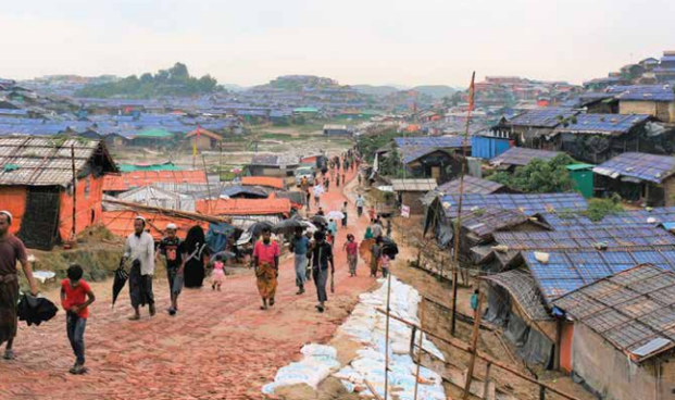 HTF Adol Rohingya – Population Council people walking down the street in a village