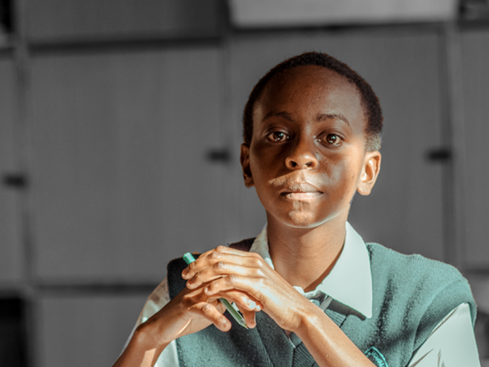 HTF Kenya – Population Council a school-aged child holding a pen