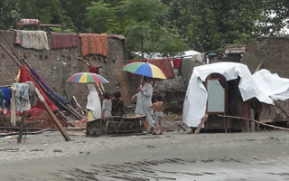 HTF Pakistan – Population Council two people outside holding umbrellas