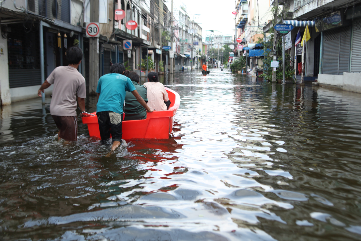 people in a boat on a flooded street