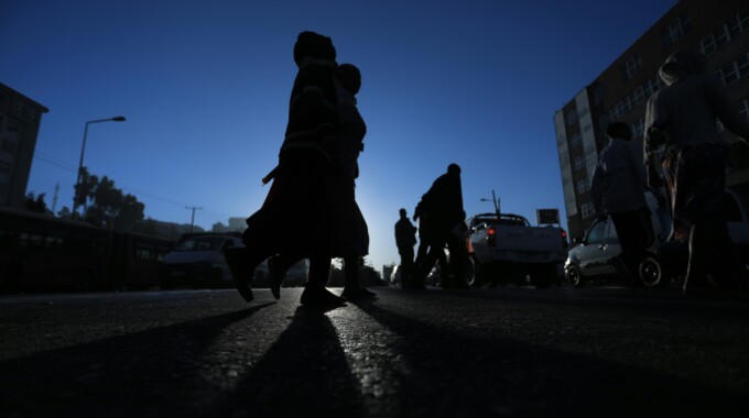 gift-habeshaw-07kA5uXaCY4-unsplash – Population Council Silhouetter of people walking in a street under a blue sky