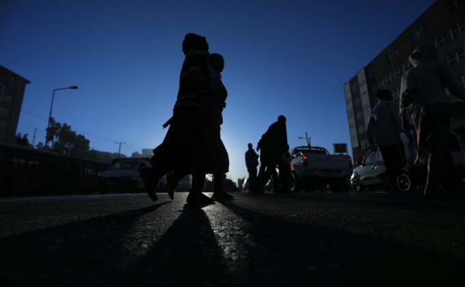 gift-habeshaw-07kA5uXaCY4-unsplash – Population Council Silhouetter of people walking in a street under a blue sky