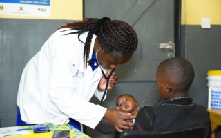 Doc_Baby4 – Population Council A healthcare worker examining an infant in their mother's arms