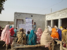 A group of women outside listening to a presentation.