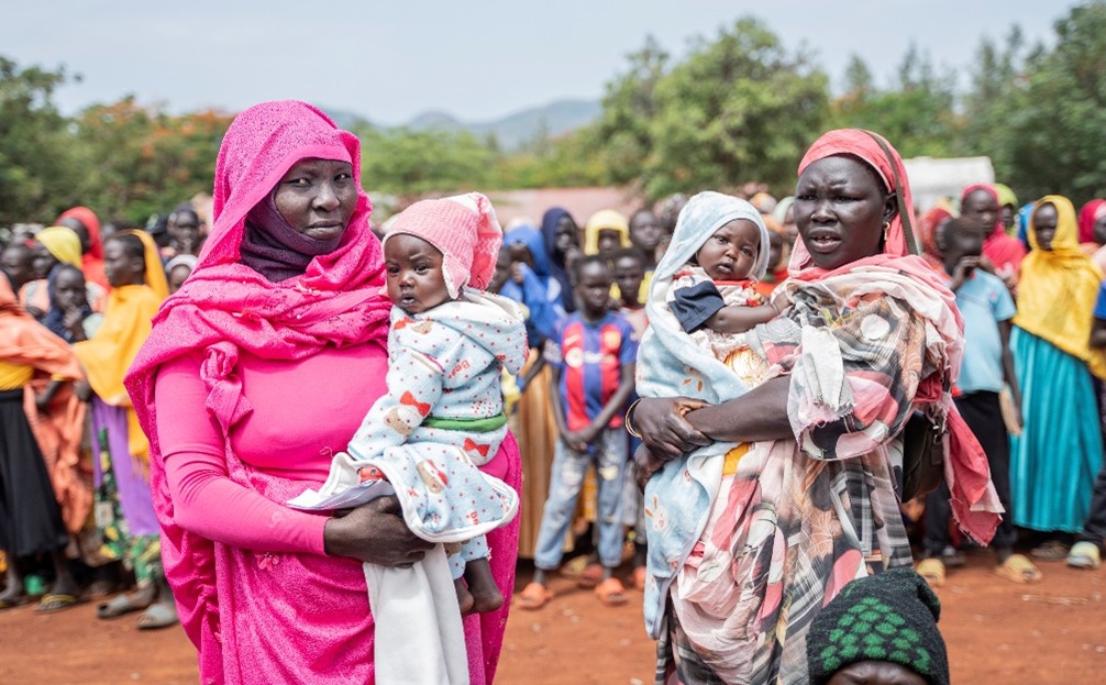 Two African female refugees each holding a baby.