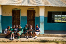 Girls reading in front of building.